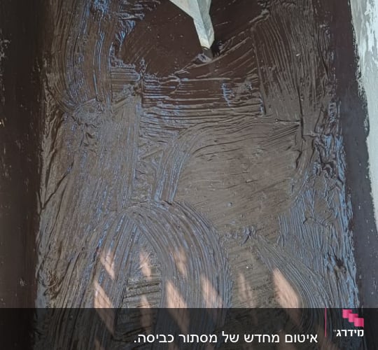 מריחת חומר איטום ביטומני על רצפה באזור דוד ומזגן